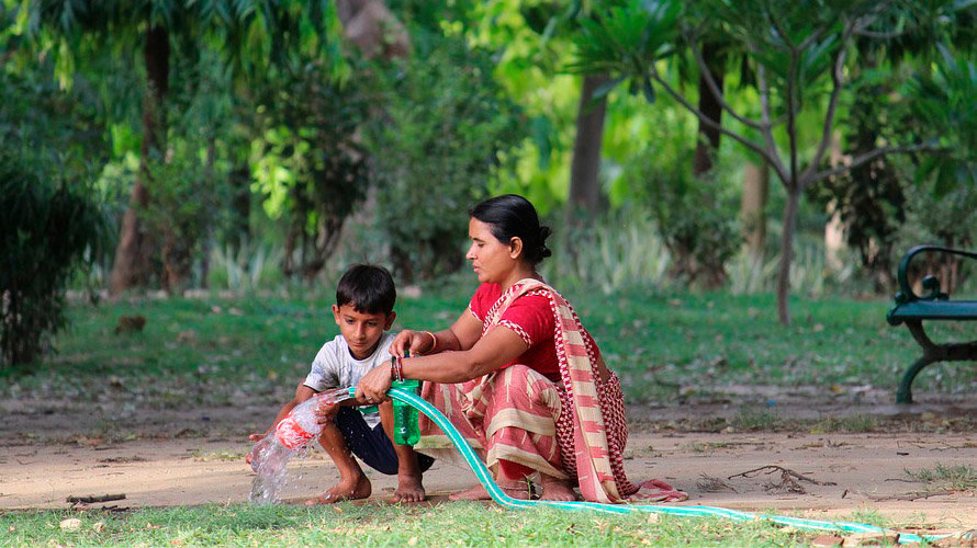 Una mujer rellena una botella de agua junto a su hijo ARCHIVO