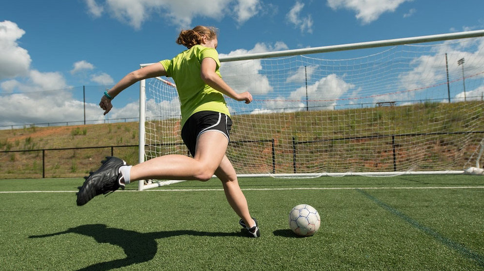 Una chica lanza un penalti durante un entrenamiento en un campo de fútbol ARCHIVO