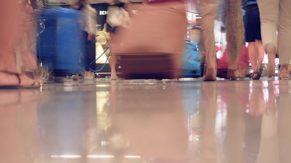 Varios viajeros andan por un aeropuerto con sus maletas ARCHIVO