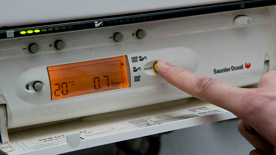 Una persona controla la temperatura de su calefacción GNF