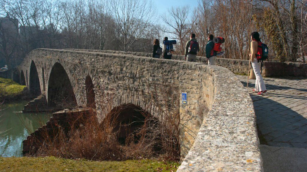 Varios peregrinos atraviesan el puente de la Magdalena, en Pamplona, en su ruta por el Camino de Santiago TURISMO DE NAVARRA