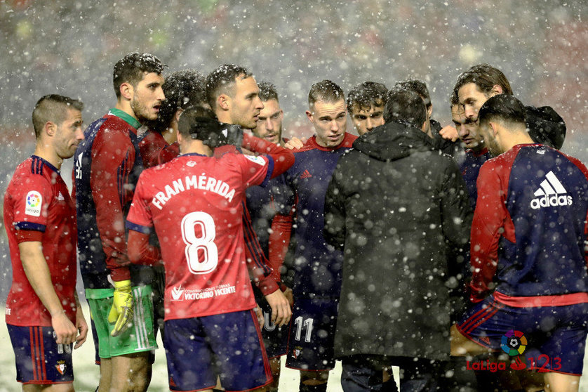 Los jugadores de Osasuna reunidos bajo la nieve en El Sadar. La Liga.