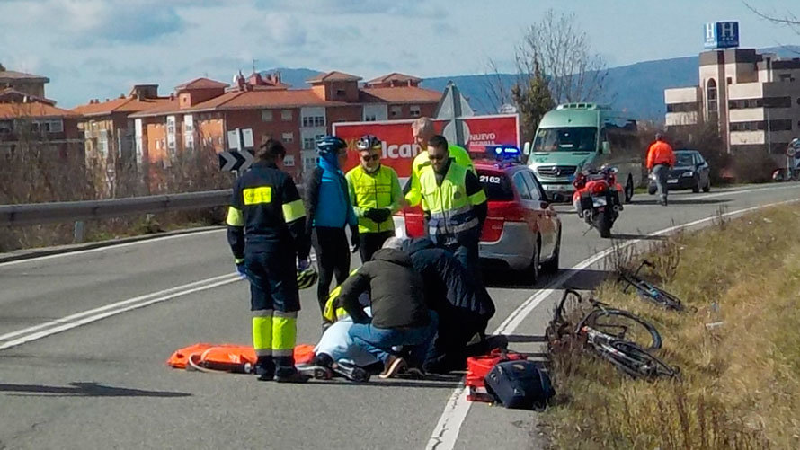 Varias personas atienden al ciclista herido en una carretera cercana a Arre. POLICÍA FORAL