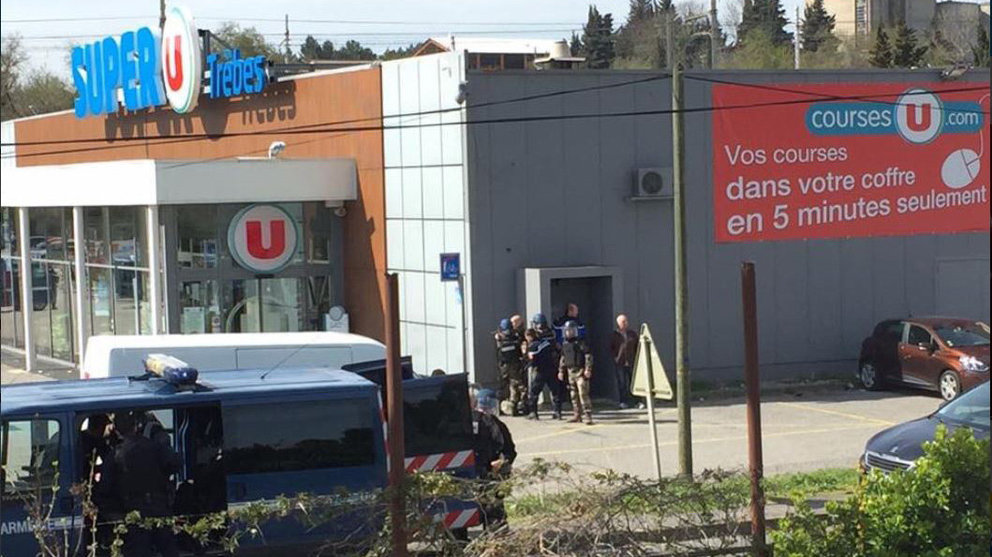 Imagen de varios agentes de policía junto al supermercado donde hay un hombre armado atrincherado. TWITTER