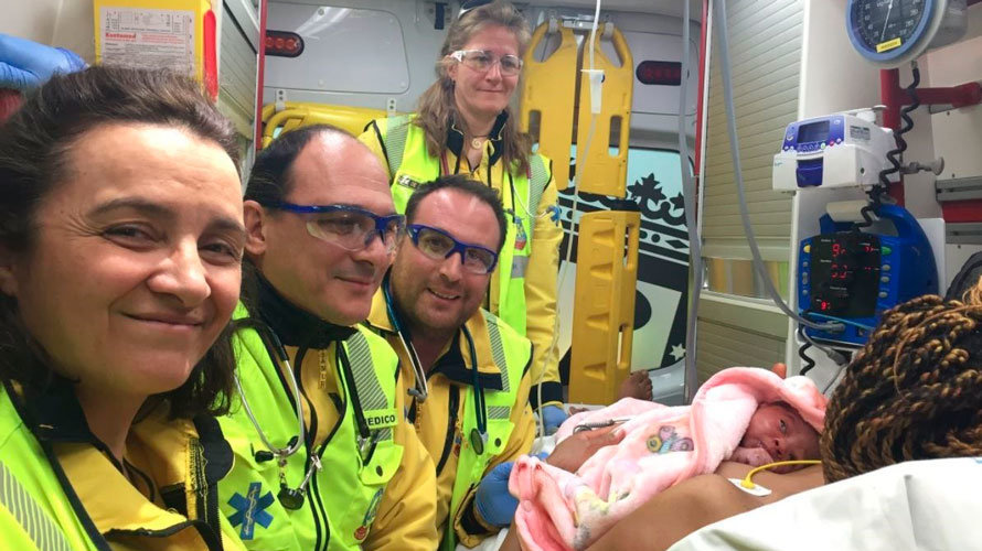 Los sanitarios posan en la ambulancia junto a la mamá y su bebé recién nacido. EMERGENCIAS MADRID