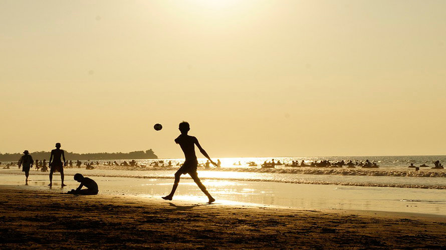 Varios niños juegan al fútbol en la playa ARCHIVO
