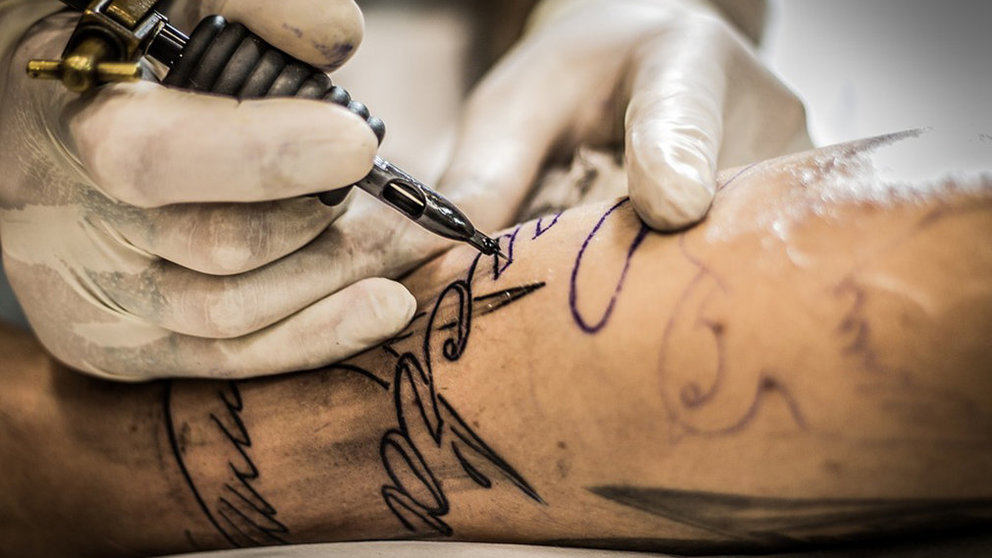 Un tatuador realiza un tatuaje a un cliente en un centro especializado ARCHIVO
