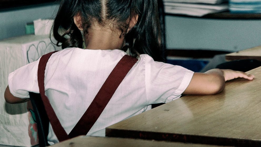 Una niña sentada de espaldas en un colegio. ARCHIVO