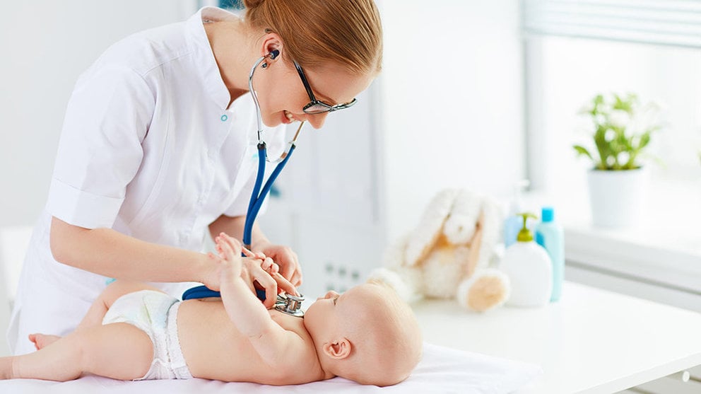 Una pediatra ausculta a un bebé de pocos meses en una consulta de un centro médico. ARCHIVO