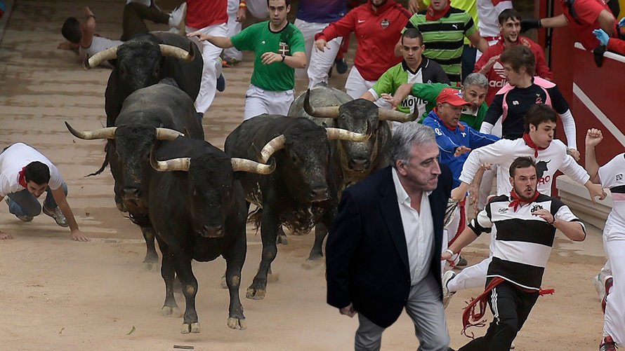 Montaje con una imagen del encierro de la ganadería Miura en 2017 y el alcalde de Pamplona Joseba Asirón PABLO LASAOSA