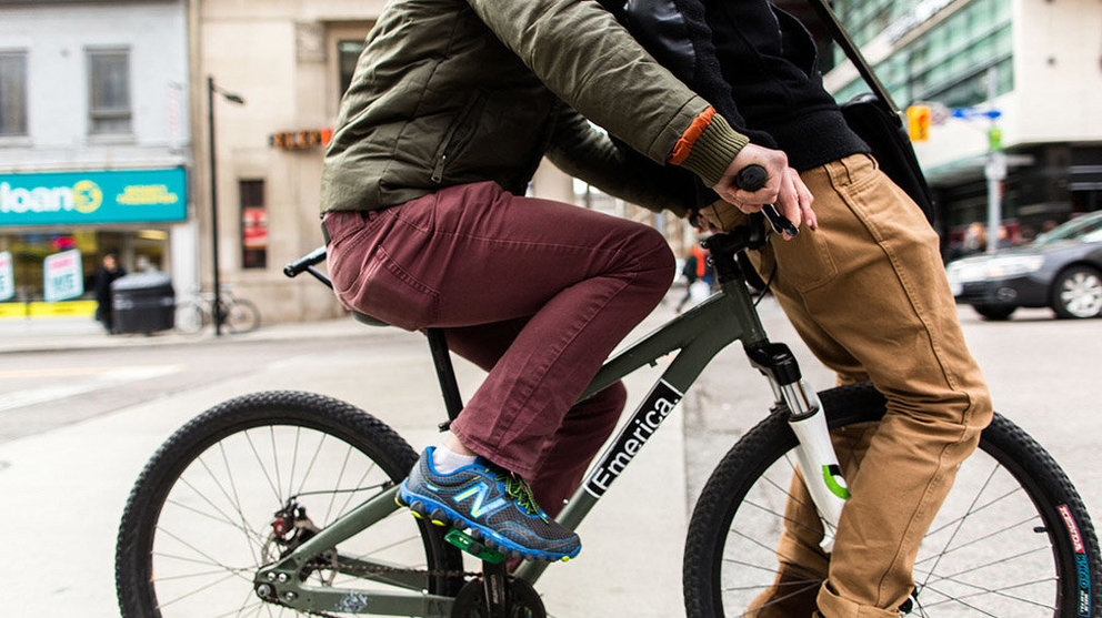 Dos jóvenes circulan en una sola bicicleta, uno sobre el sillín y otro en el manillar ARCHIVO