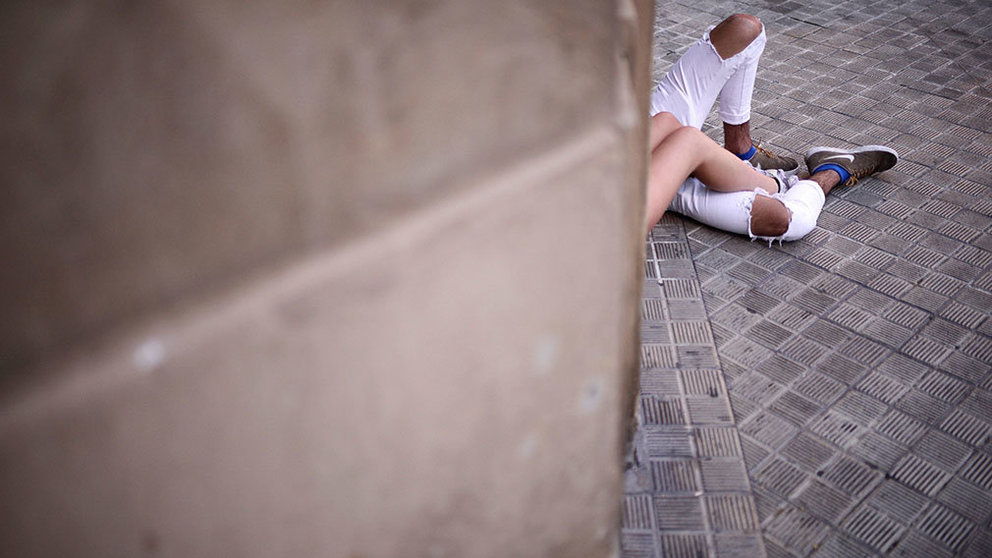 Una pareja descansa en la calle después de una larga noche de fiesta de San Fermín. REUTERS/Vincent West