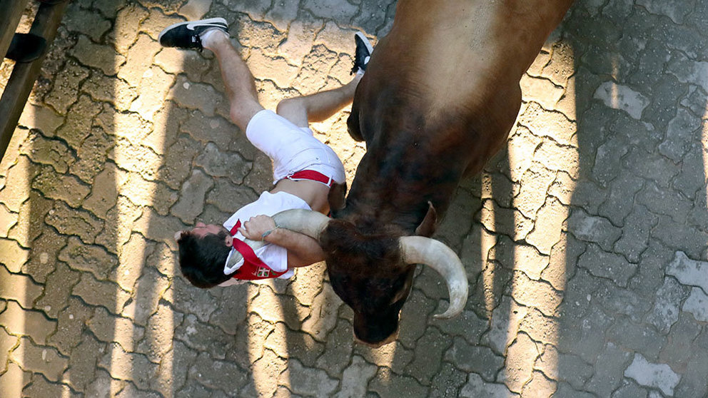 Un mozo es enganchado y golpeado por un toro de Miura por la camiseta y el pañuelo en el callejón durante el octavo encierro de San Fermín 2018. REUTERS/Susana Vera