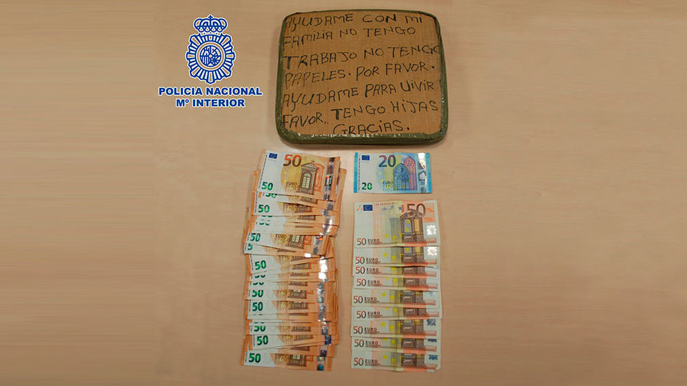 Dinero en efectivo hallado en su domicilio junto a un cartel que el hombre usaba para pedir dinero POLICÍA NACIONAL