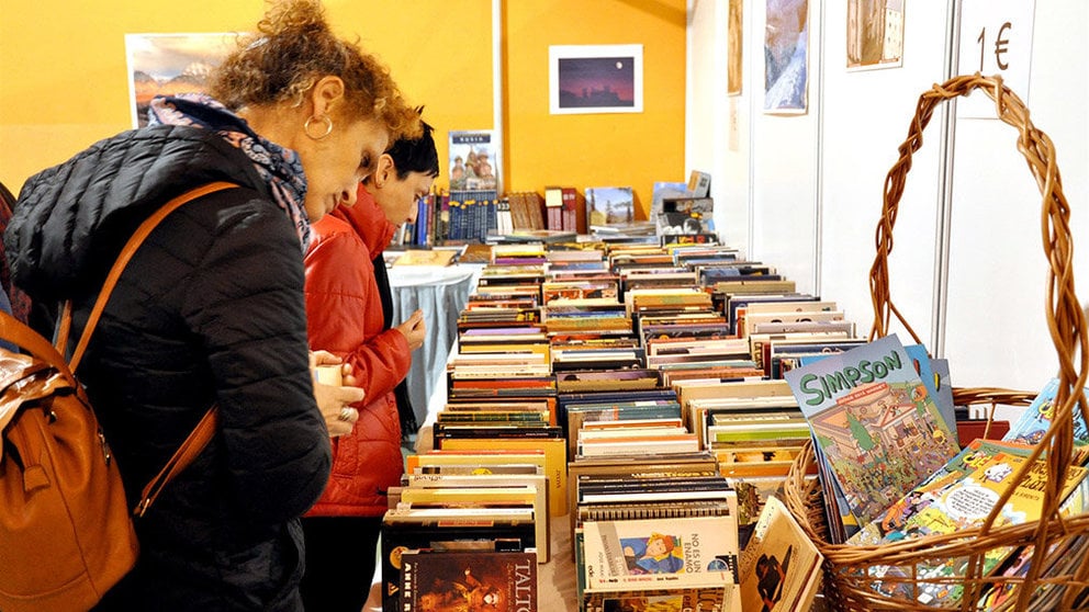Una mujer consulta unos libros en un mercadillo solidario. NUEVO FUTURO