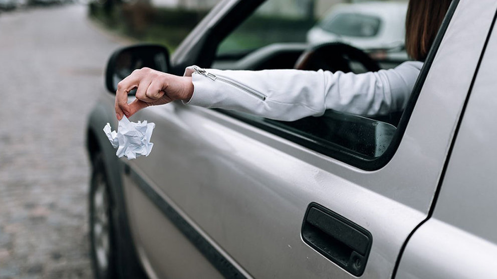 Imagen de una persona conduciendo un coche y lanzando un papel por la ventanilla ARCHIVO
