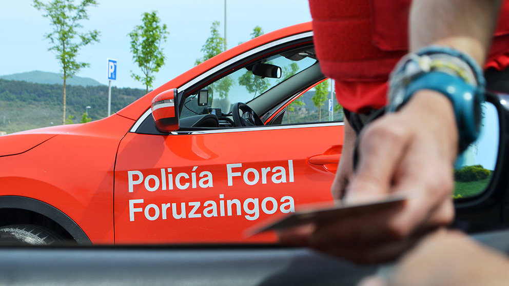 Un agente revisa el carné de conducir de un conductor en un control de seguridad establecido en la carretera POLICÍA FORAL