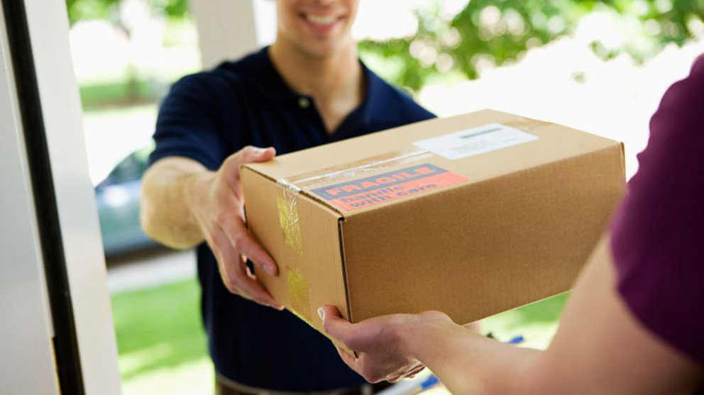 Imagen de un repartido entregando un paquete de mercancía tras una compra por internet ARCHIVO