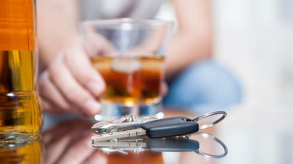 Imagen de un conductor bebiendo un vaso de licor antes de coger las llaves de su coche para conducir el vehículo ARCHIVO