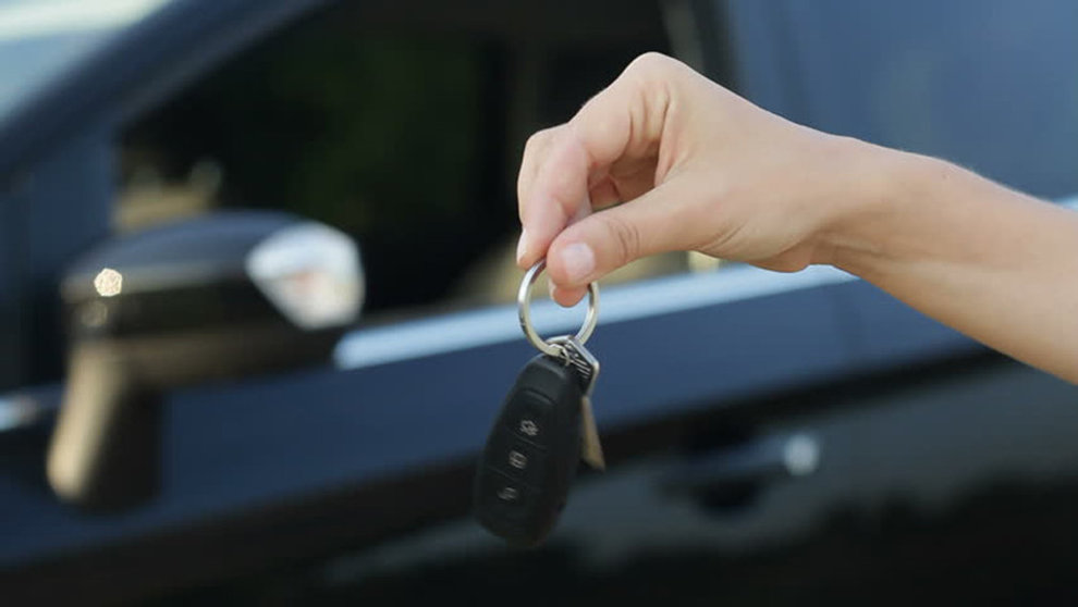 Imagen de una persona con el mando a distancia y la llave para abrir un coche ARCHIVO