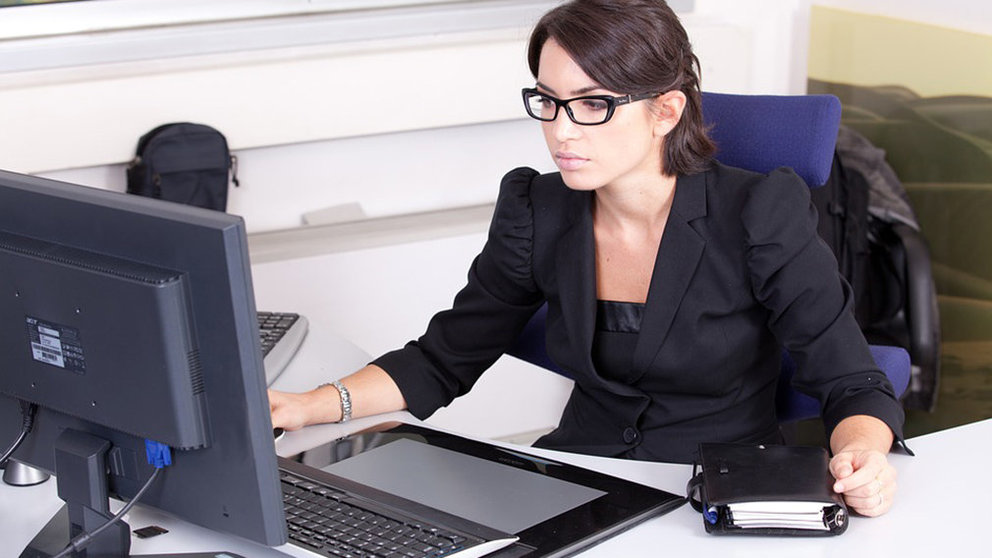 Una mujer trabaja en la oficina de su empresa junto a un ordenador y una agenda. ARCHIVO
