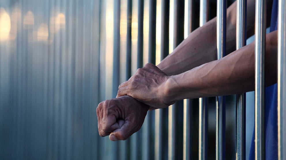 Imagen de un preso encarcelado en una prisión y sacando los brazos por los barrotes de la celda ARCHIVO