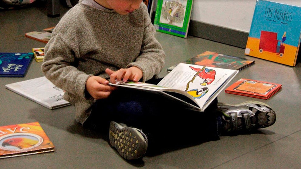 Un niño leyendo en la biblioteca infantil CIVICAN