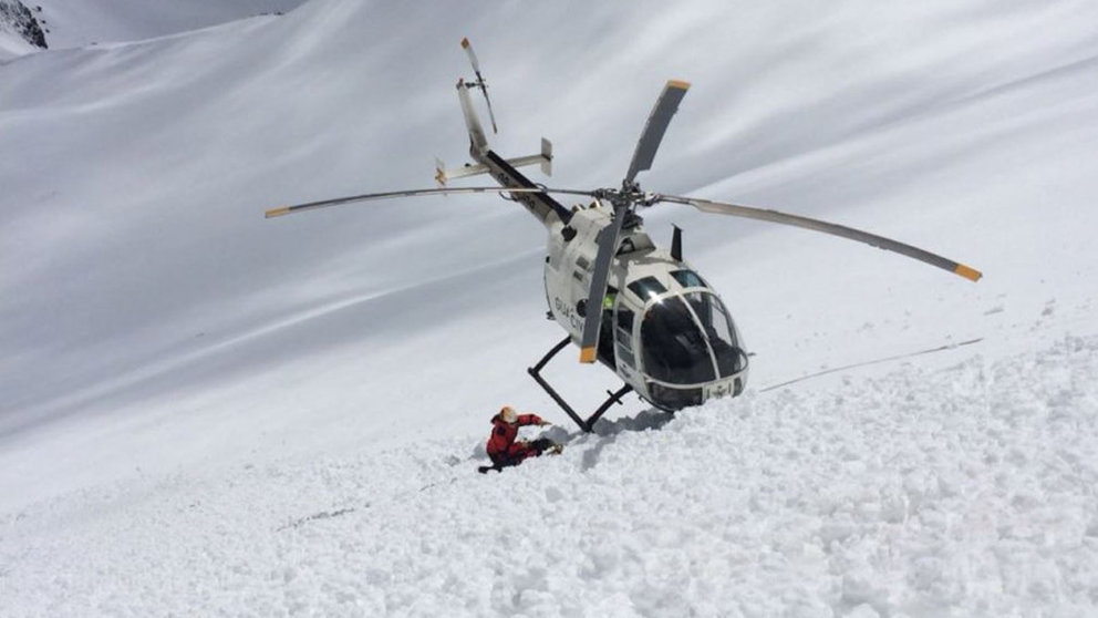 Un helicóptero del GREIM rescata a un esquiador tras sufrir un accidente en la ladera de una montaña nevada. Foto: GUARDIA CIVIL