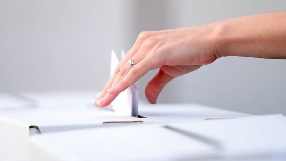 Una persona deja su voto en una urna durante las elecciones ARCHIVO