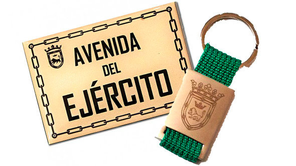 La placa de la calle Avenida del Ejército y el llavero con el escudo de Pamplona.