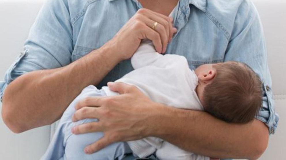 Un padre sujeta entre sus brazos a un bebé ARCHIVO