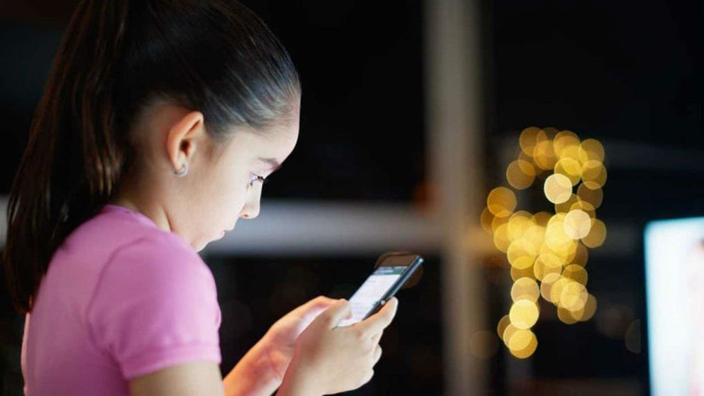 Imagen de archivo de una joven adolescente escribiendo un mensaje a través de una red social en su teléfono móvil ARCHIVO