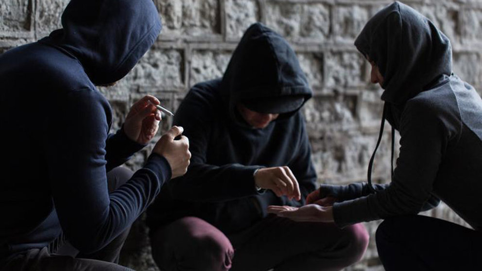 Varios jóvenes encapuchados trafican con droga en una calle ARCHIVO