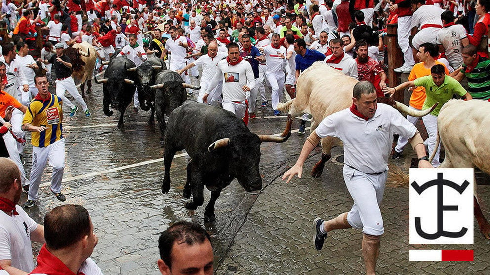 Corredores y toros de la ganadería de José Escolar a su paso por el tramo de Telefónica hacia el callejón, durante el segundo encierro de San Fermín en Pamplona EFE - Daniel Fernández