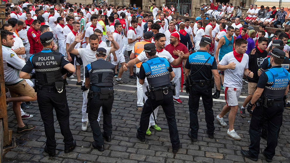 Agentes de la policía municipal de Pamplona realizando varios registros a corredores antes del séptimo encierro de los Sanfermines 2019.-   EFE/EPA/JIM HOLLANDER