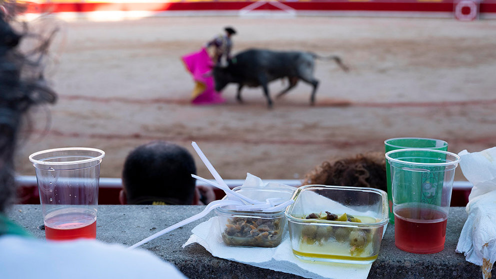 Merienda de un grupo de espectadores de sombra en la última corrida de Sanfermines con toros de Miura. EFE/EPA/JIM HOLLANDER