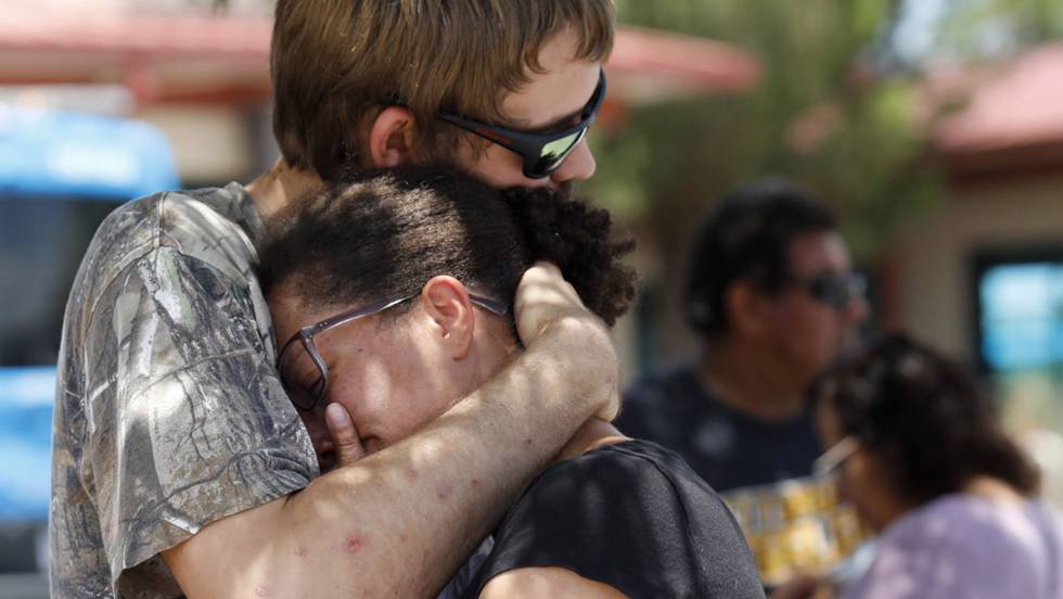 Dos personas lloran tras el tiroteo que ha dejado 20 muertos en el paso, texas