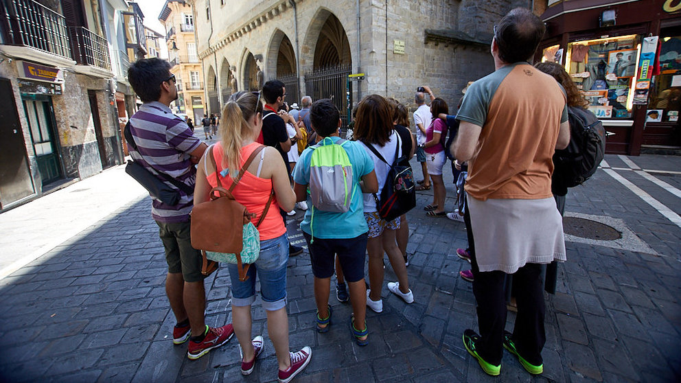 Varios turistas atienden las explicaciones de un guía en el casco viejo de Pamplona. IÑIGO ALZUGARAY