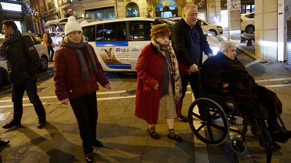 El alcalde, Enrique Maya, recibe a personas de residencias de la tercera edad que recorren en taxi la ciudad para ver las luces y el ambiente navideño de Pamplona. IÑIGO ALZUGARAY