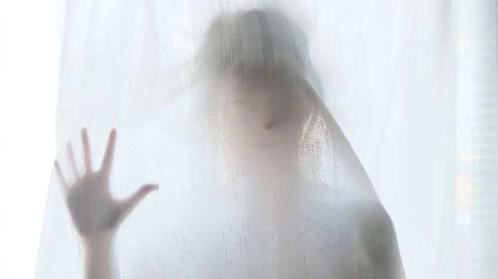 Una mujer tras una cortina ARCHIVO