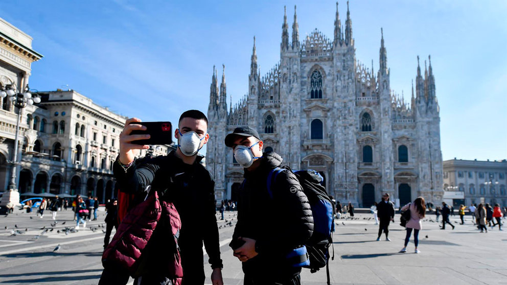Dos turistas posan con mascarillas de protección frente al coronavirus en el Duomo de Milán. EUROPA PRESS