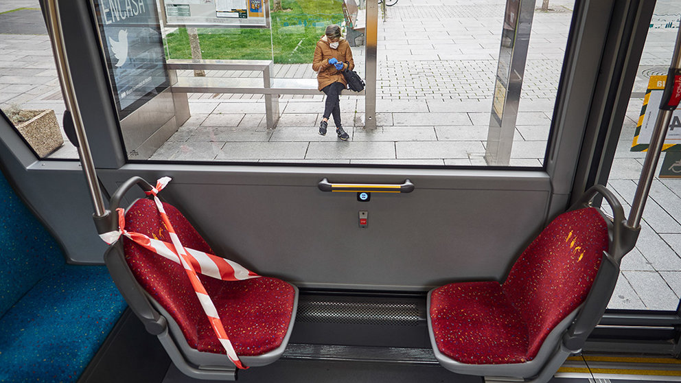 Interior de un autobús urbano con un asiento precintado desde el que se ve a una mujer protegida con mascarilla y guantes sentada en un banco de una marquesina, durante la cuarta semana del estado de alarma, en Pamplona (Navarra) a 6 de abril de 2020.

CORONAVIRUS;PANDEMIA;COVID-19;SEMANA SANTA

6/4/2020