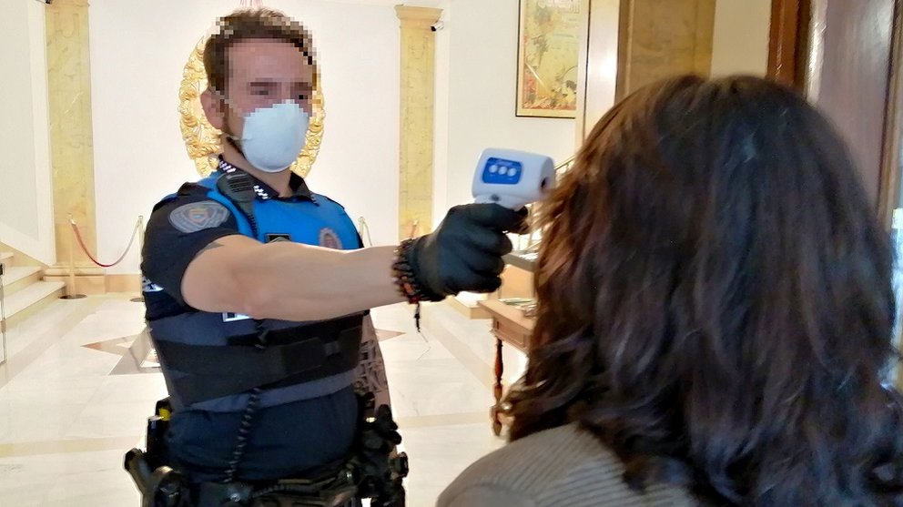 Un policía municipal toma la temperatura de una mujer. AYUNTAMIENTO DE PAMPLONA