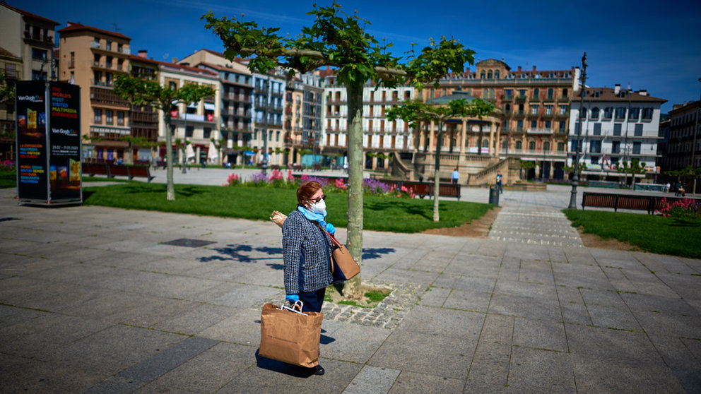 Una señora con mascarilla camina por la Plaza del Castillo durante la crisis del coronavirus. Miguel Osés