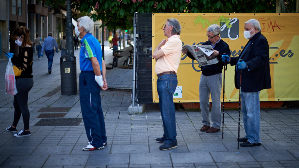 Varias personas con mascarilla hacen cola para entrar en un establecimiento durante la crisis del coronavirus en Pamplona. Miguel Osés
