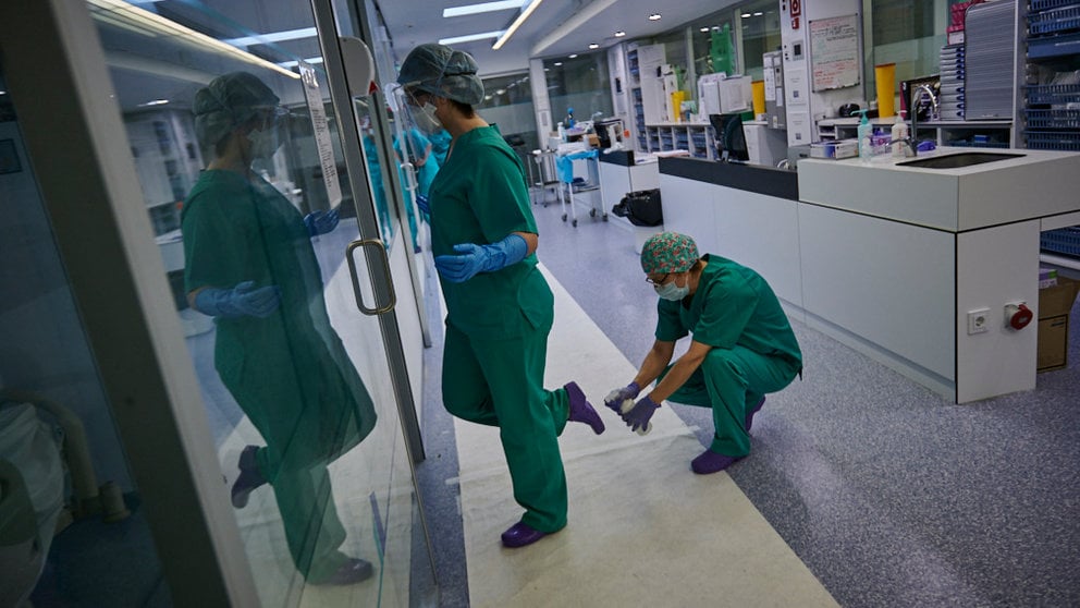 Una enfermera desinfecta las zapatillas a otra tras salir de tratar a una persona con coronavirus. PABLO LASAOSA