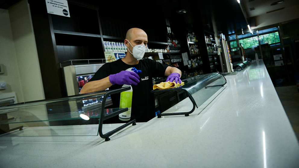 Raúl Montoya, del bar Boulevard de la Rochapea, limpia la barra en preparación para la fase 1 de la desescalada por la crisis del coronavirus. PABLO LASAOSA