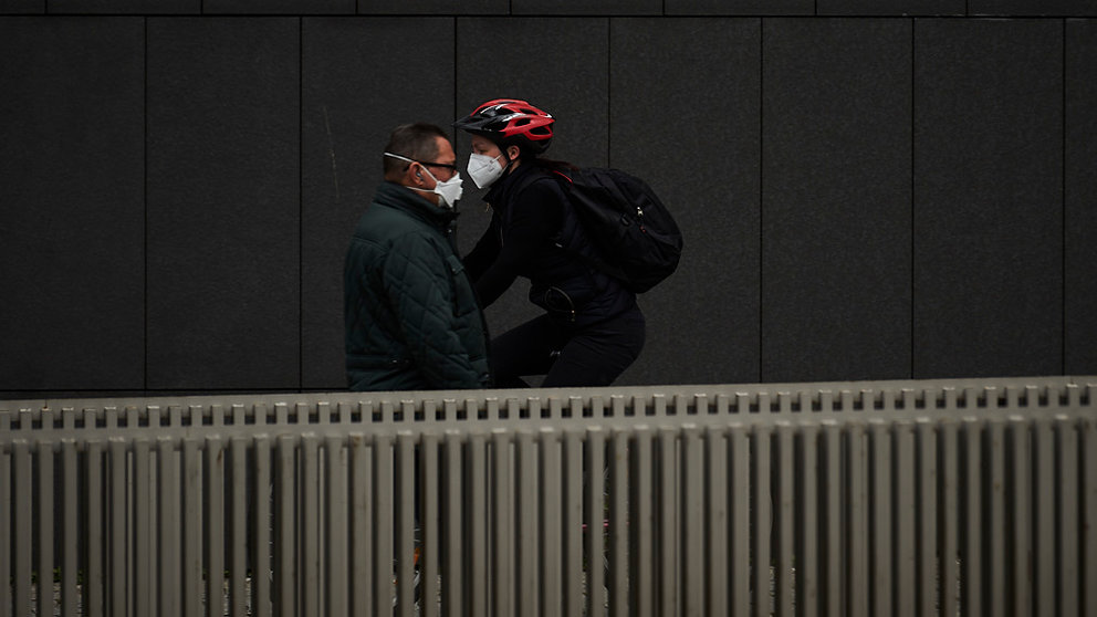 Una persona con una mascarilla y una persona en bici por Pamplona durante la crisis del coronavirus. PABLO LASAOSA
