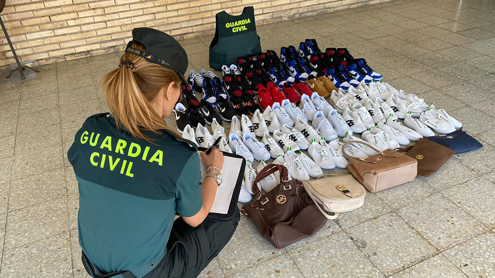 Una agente de la Guardia Civil de Navarra interviene un centenar de pares de zapatillas deportivas ilegales. CEDIDA