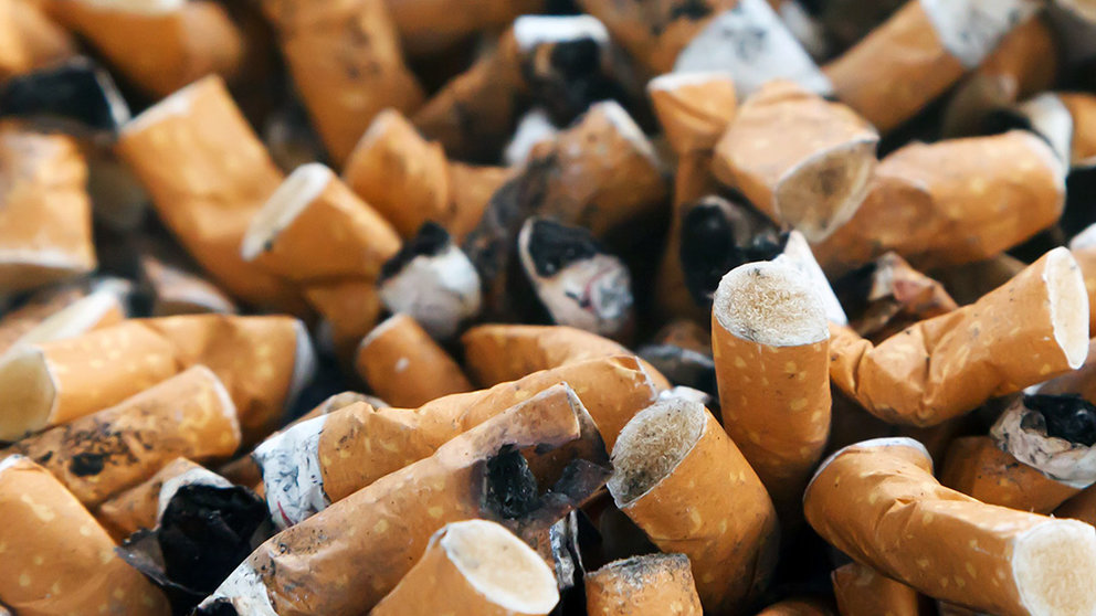 Decenas de colillas de cigarrillos apagadas sobre un cenicero. 